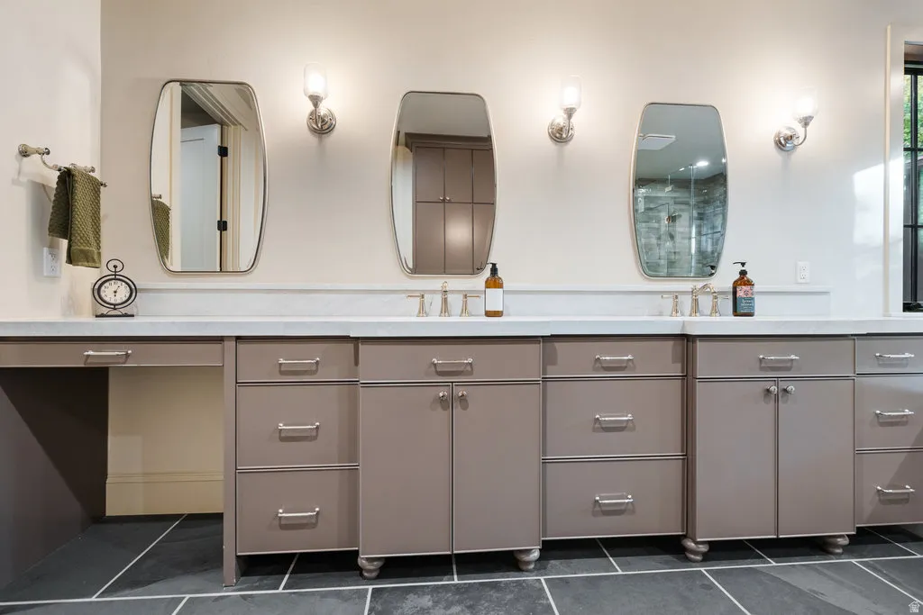 Dual vanity featuring a light countertop, integrated sinks, brushed nickel fixtures, and multiple storage cabinets with drawers