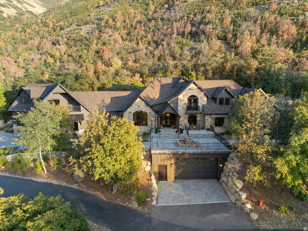 Stone and timber-clad residence with multiple gables and a prominent arched entryway