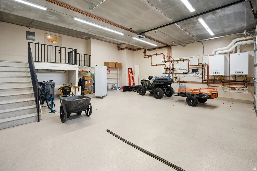 LOWER Multi-purpose garage space featuring a concrete ceiling, industrial lighting, and a neutral-toned epoxy floor