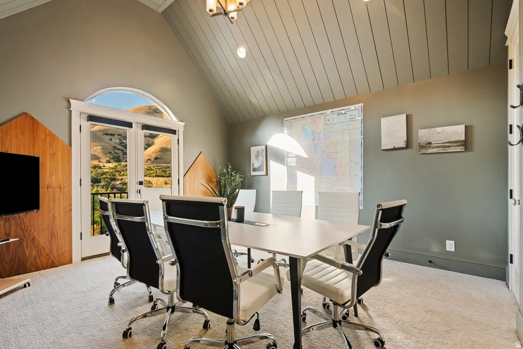 Vaulted ceiling with shiplap detail, arched transom window, and double French doors opening to a balcony