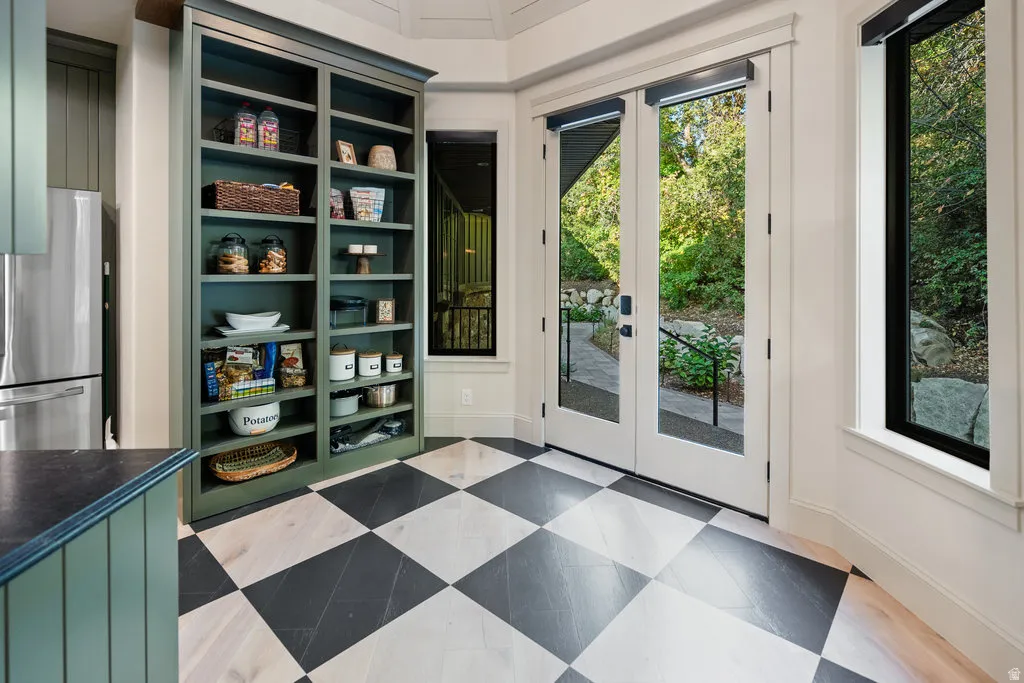 Checkerboard wood-finish flooring with dual pane French doors to the exterior