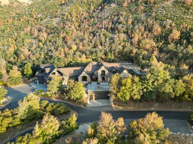 Expansive property featuring a multi-level residence with stone and wood siding
