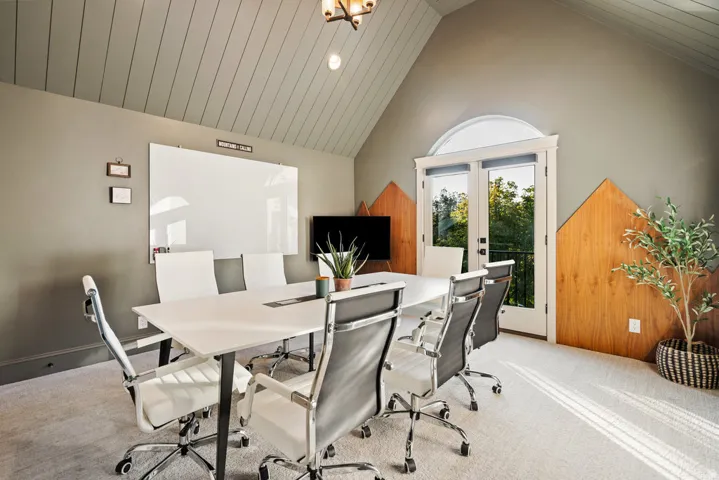 Room featuring a vaulted ceiling with horizontal paneling, light gray painted walls, and light-colored carpeting