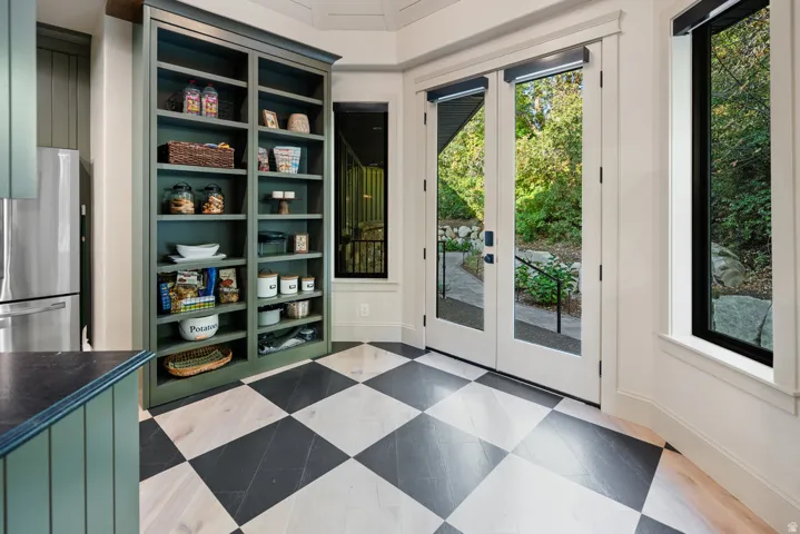 Checkerboard wood-finish flooring with dual pane French doors to the exterior