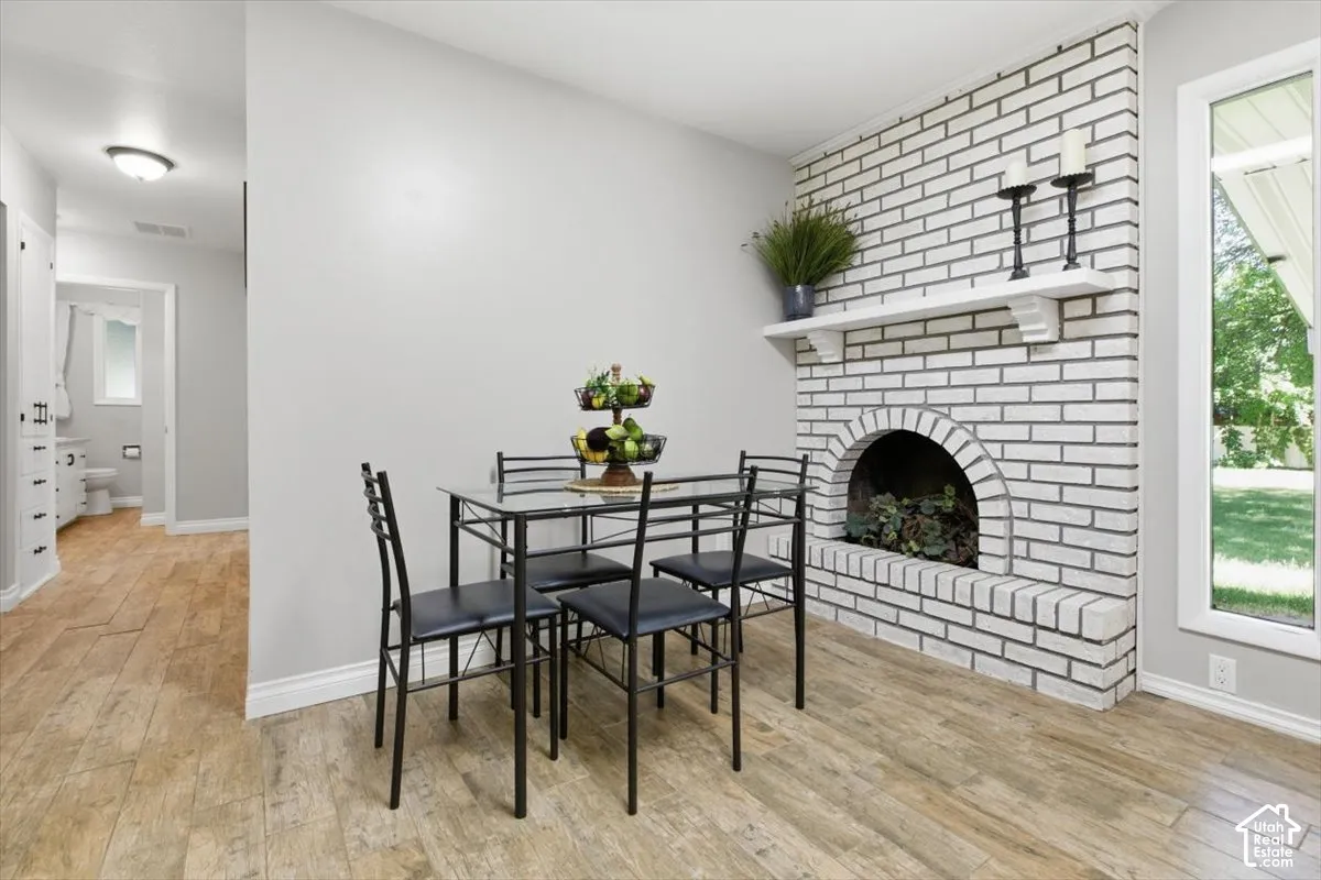 Dining area featuring a white painted brick fireplace with an arched firebox and a white mantel