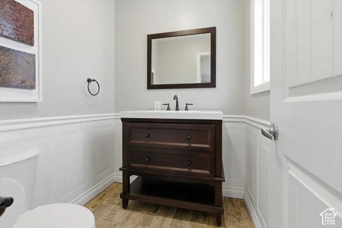 Bathroom featuring a dark wood vanity with white countertop, framed mirror, and matte black faucet
