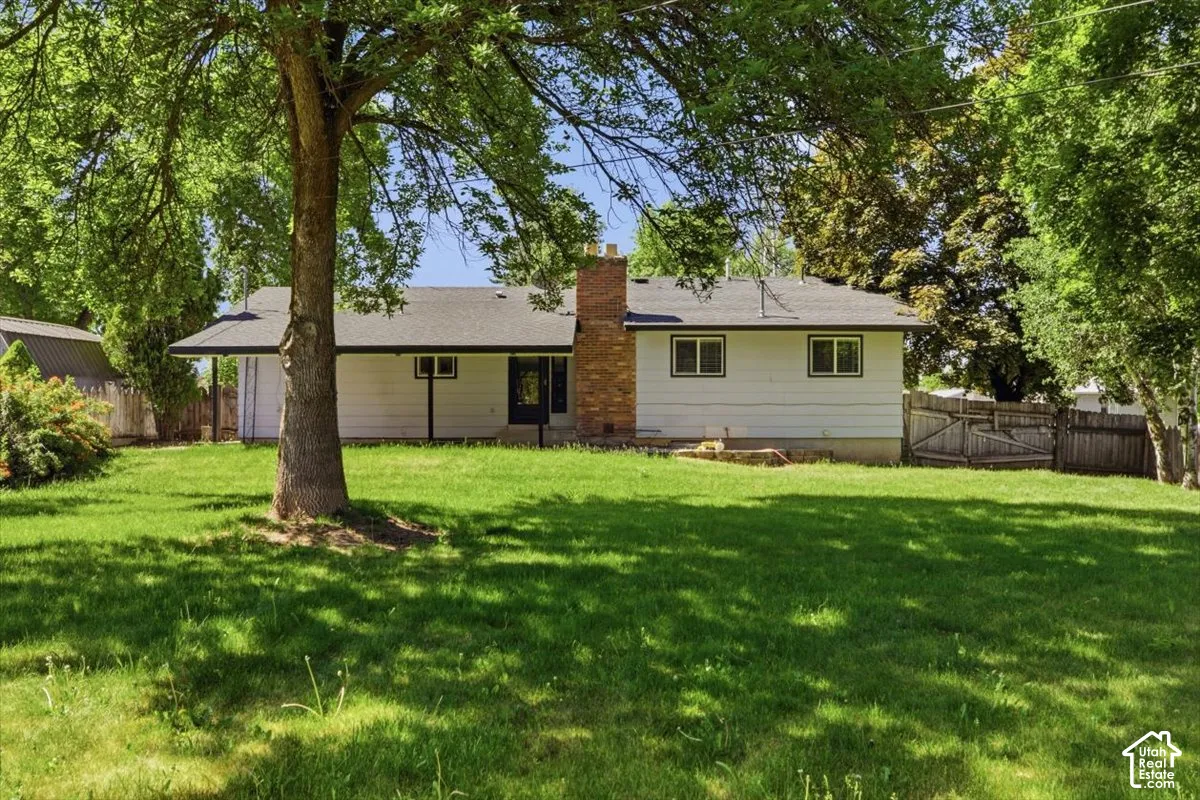 Expansive green lawn with mature trees providing shade