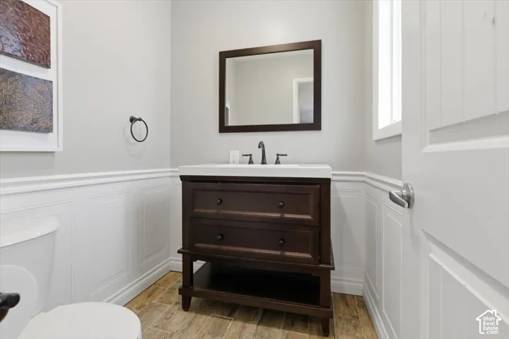 Bathroom featuring a dark wood vanity with white countertop, framed mirror, and matte black faucet