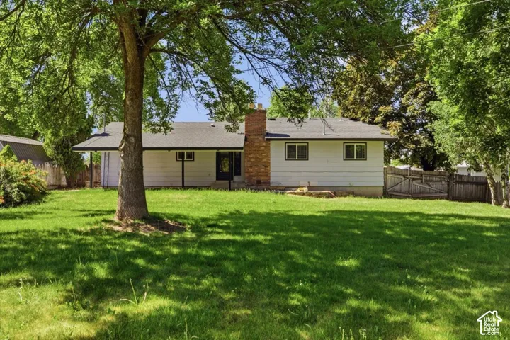 Expansive green lawn with mature trees providing shade