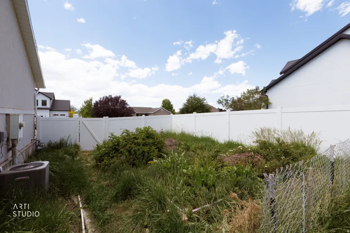 Enclosed yard area with a white vinyl fence and gate