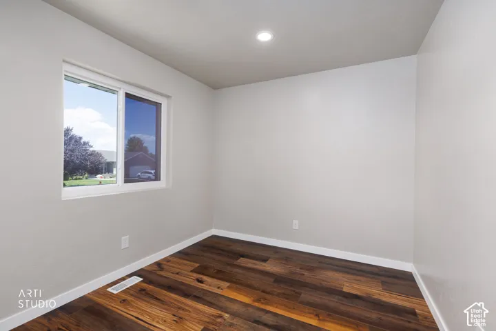 Room featuring wood-finish flooring, a white window frame, and recessed ceiling lighting