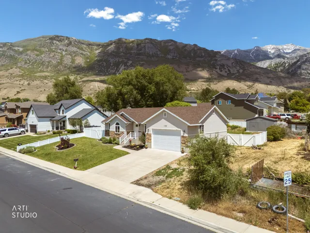 Single-story residence featuring a two-car garage, stone and siding exterior, and a manicured front lawn