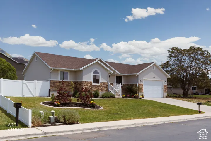 Ranch-style residence featuring a stucco and stone veneer exterior with a brown shingle roof