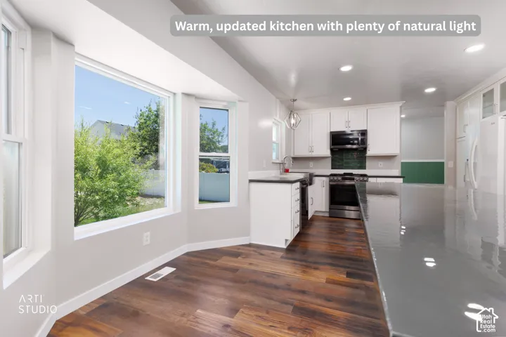 Kitchen featuring dark wood-finish flooring and a bright bay window