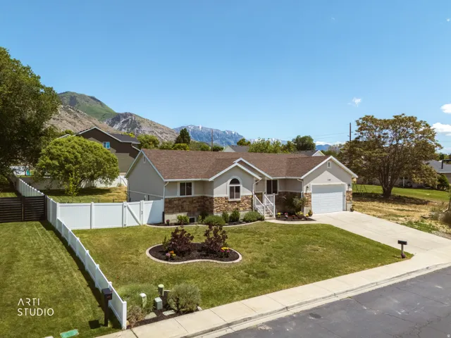 Single-story residence featuring a stone and stucco facade, an attached garage, and a concrete driveway