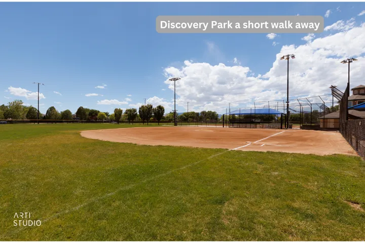 Baseball field featuring a dirt infield, grass outfield, perimeter fencing, and stadium lighting
