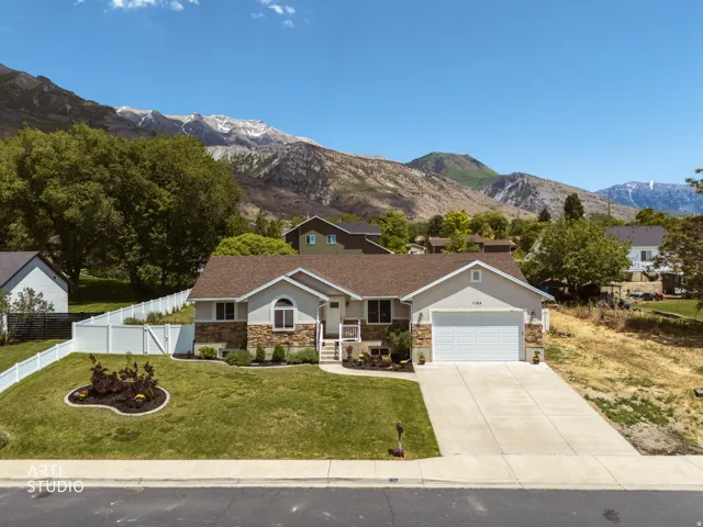 Ranch-style residence featuring a stone veneer facade, integrated two-car garage, and a concrete driveway