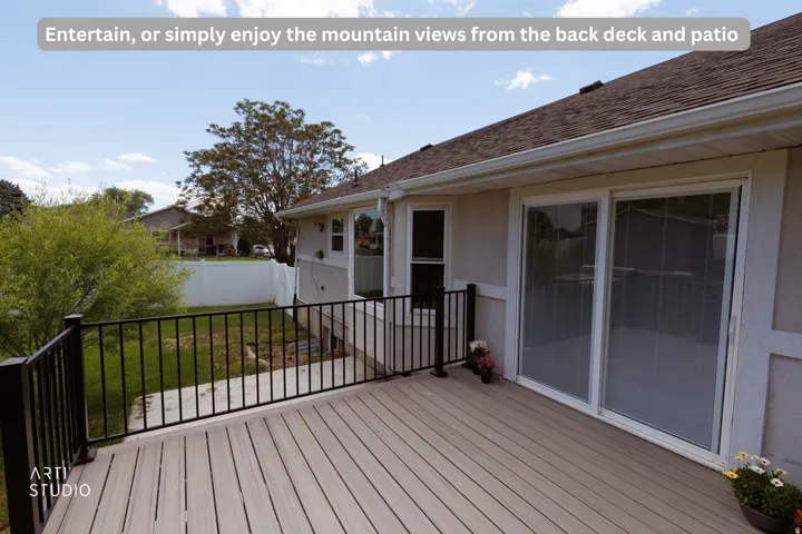 Expansive composite deck featuring black metal railings and direct access to the interior via sliding glass doors