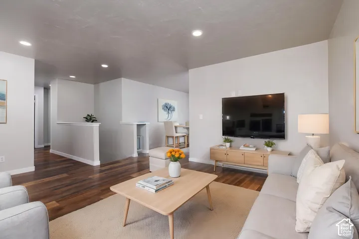 Spacious living area featuring wood-finish flooring, recessed lighting, and a neutral color palette