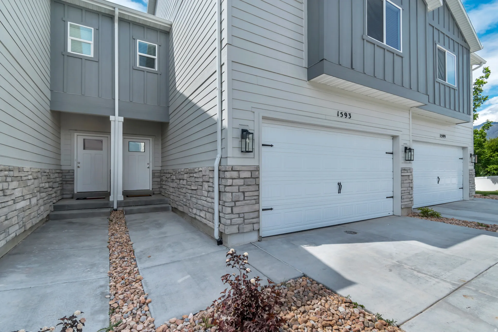 Contemporary facade featuring light gray horizontal siding and darker gray vertical siding accents