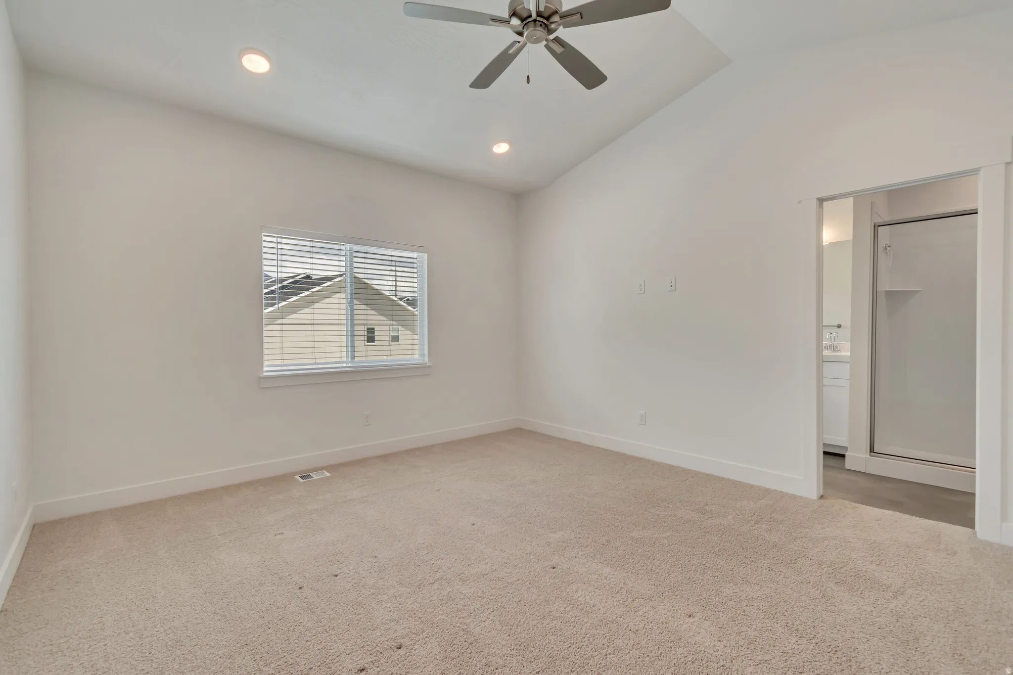 Spacious room featuring vaulted ceilings, recessed lighting, and a ceiling fan