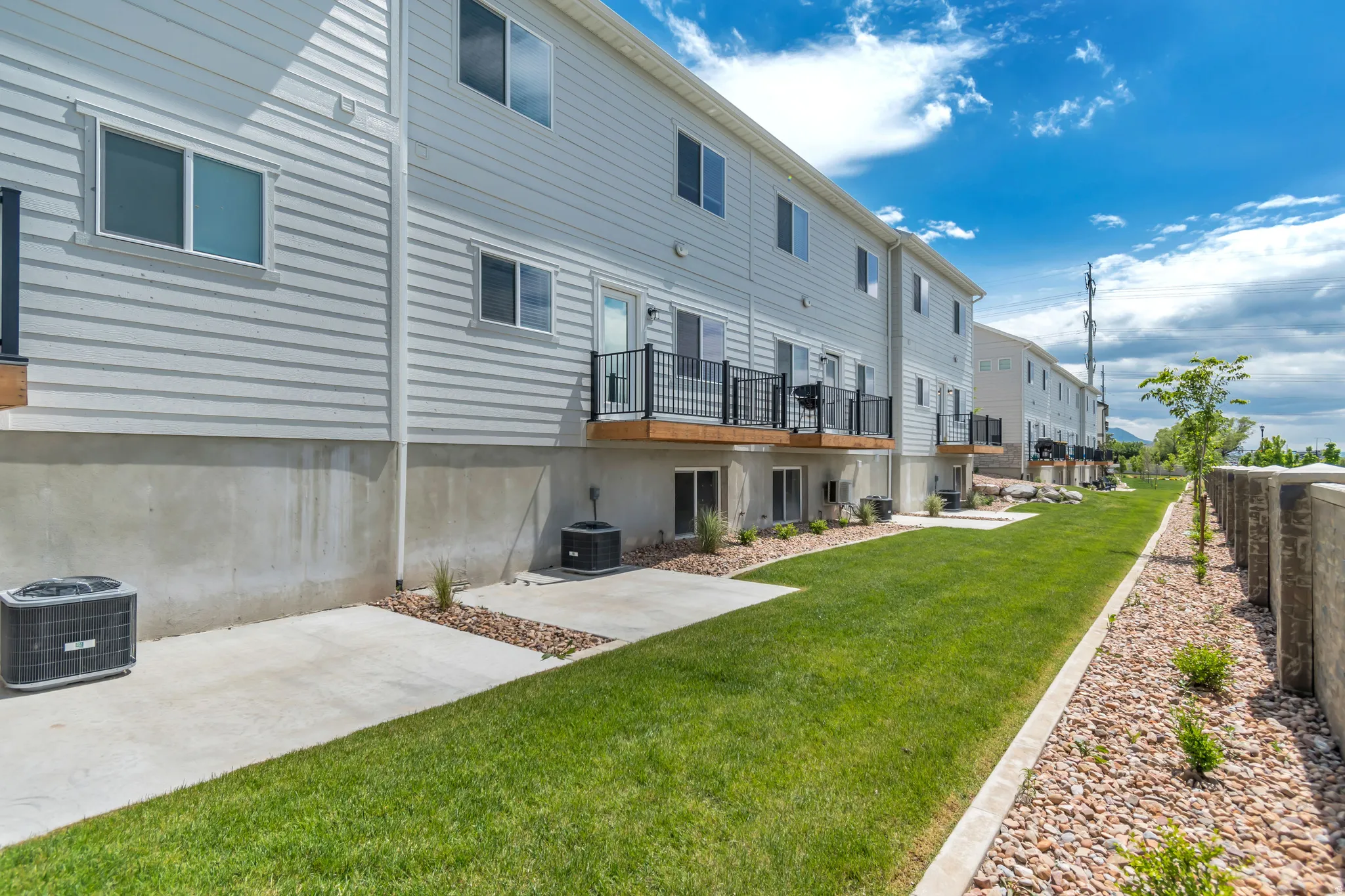 Rear exterior featuring white horizontal siding and a concrete foundation
