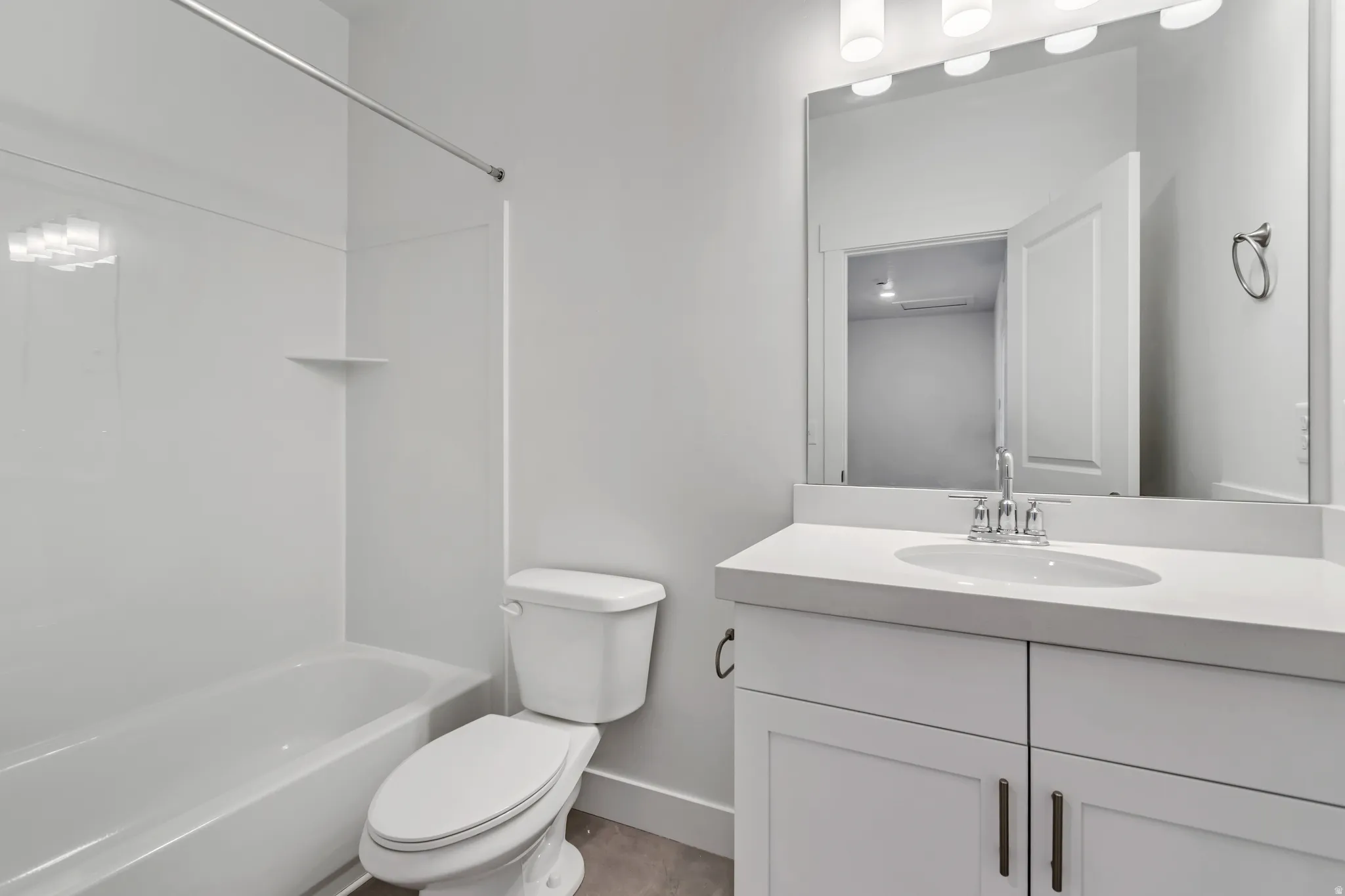 Bathroom featuring a white vanity with an integrated sink, polished chrome faucet, and a large wall mirror