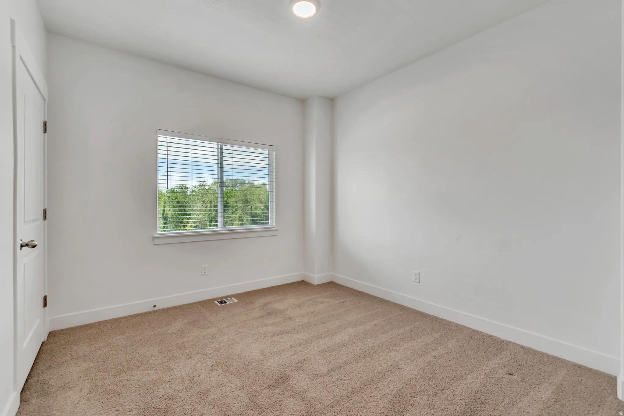 Neutral wall tones with a window featuring horizontal blinds