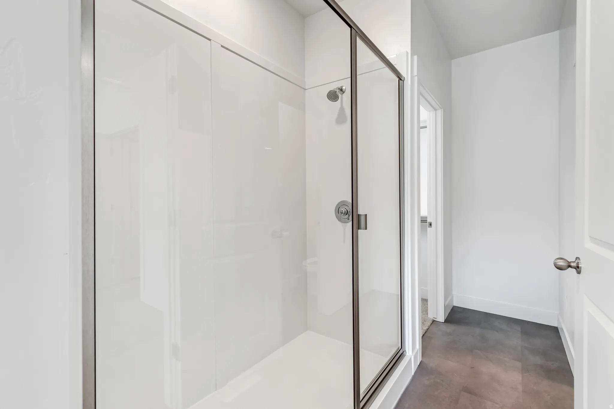 Contemporary shower enclosure featuring a sliding glass door and brushed nickel hardware