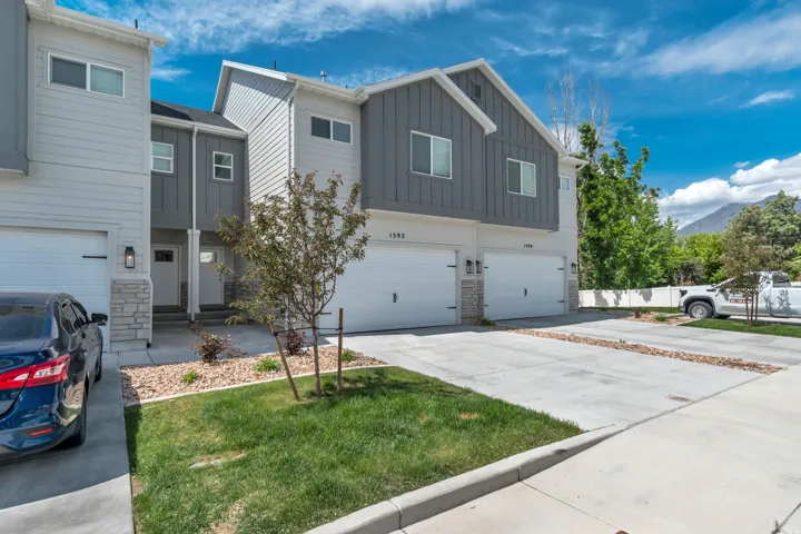 Modern townhome exterior featuring light gray horizontal siding and dark gray board and batten accents
