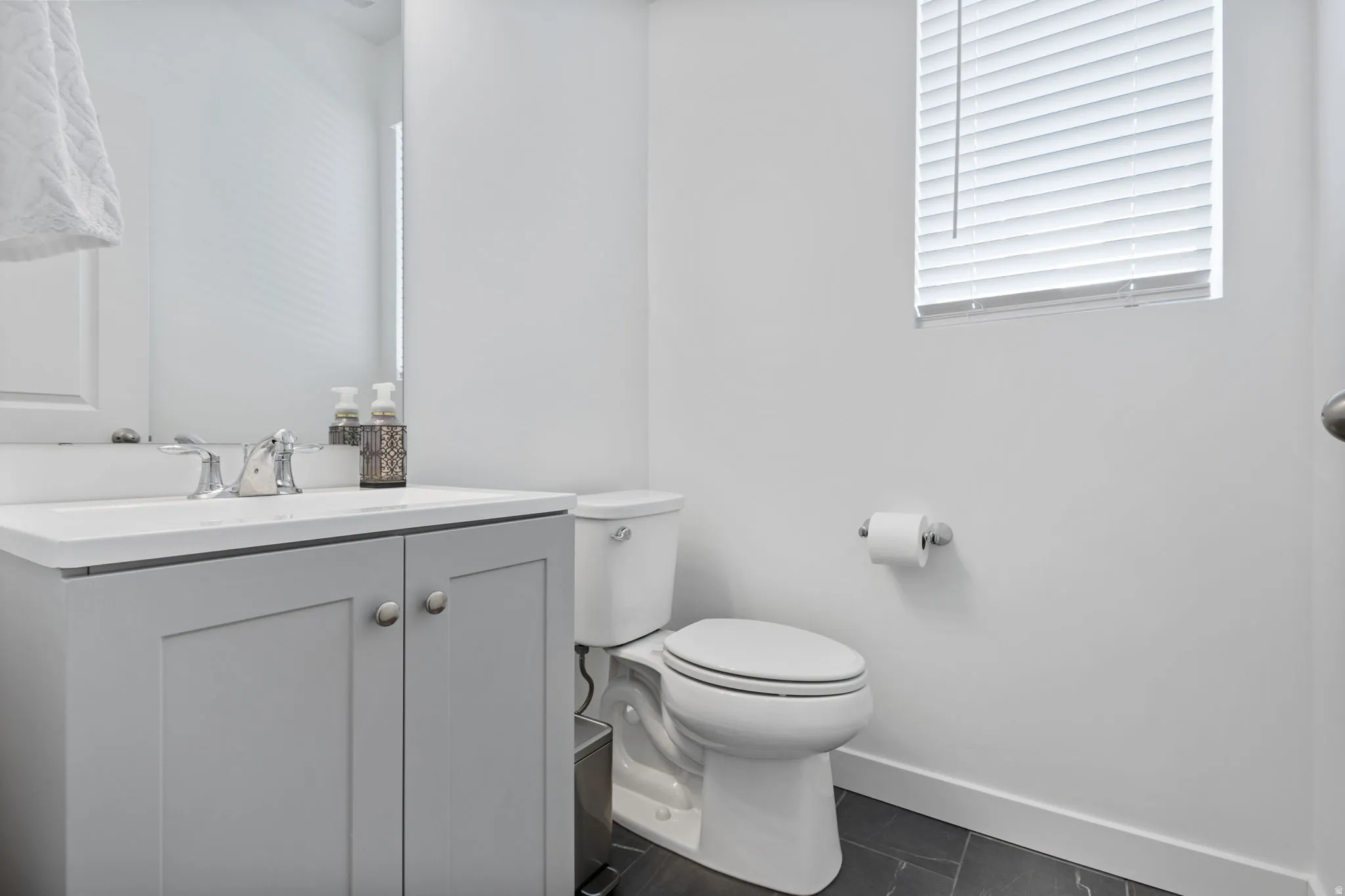 Bathroom featuring a light gray vanity with a white quartz countertop