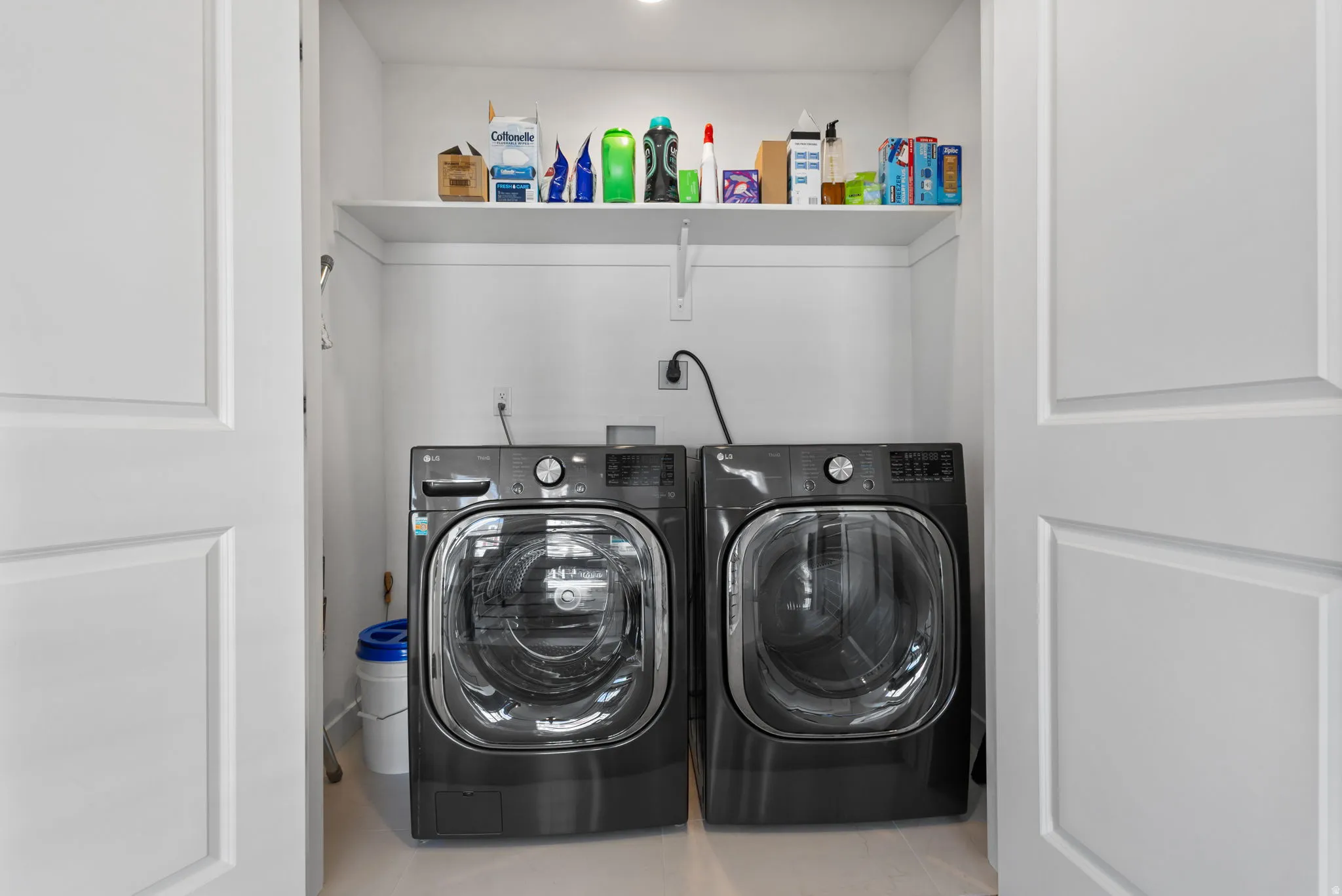 Dedicated laundry area upstairs featuring a white storage shelf, recessed lighting, and white paneled doors
