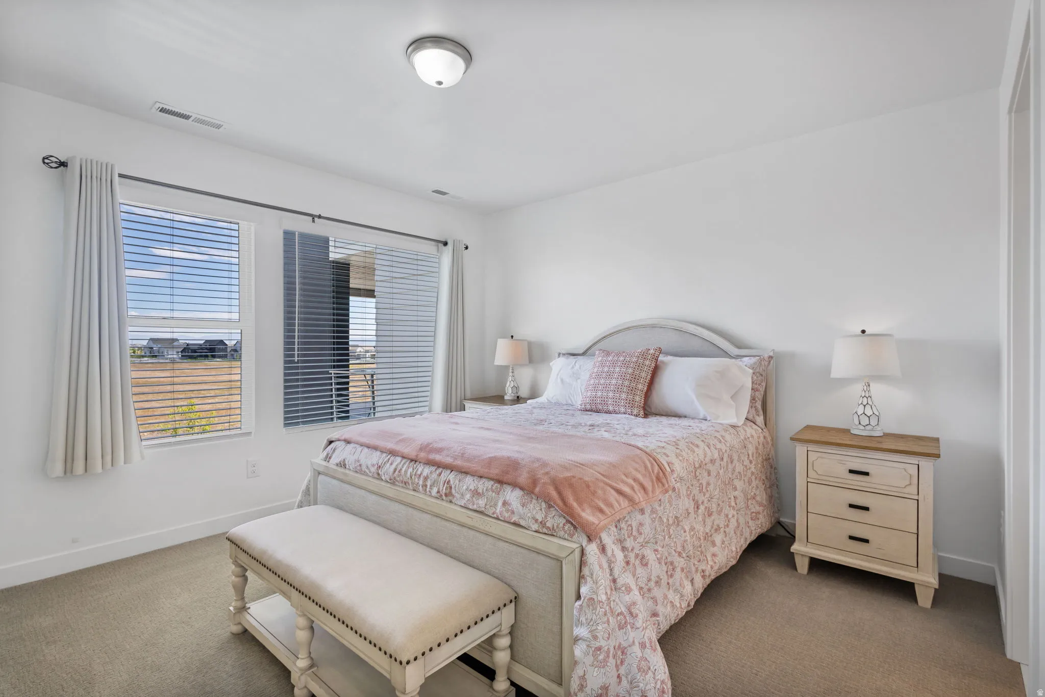 Carpeted primary bedroom with flush mount lighting and plenty of space for furniture and to walk around