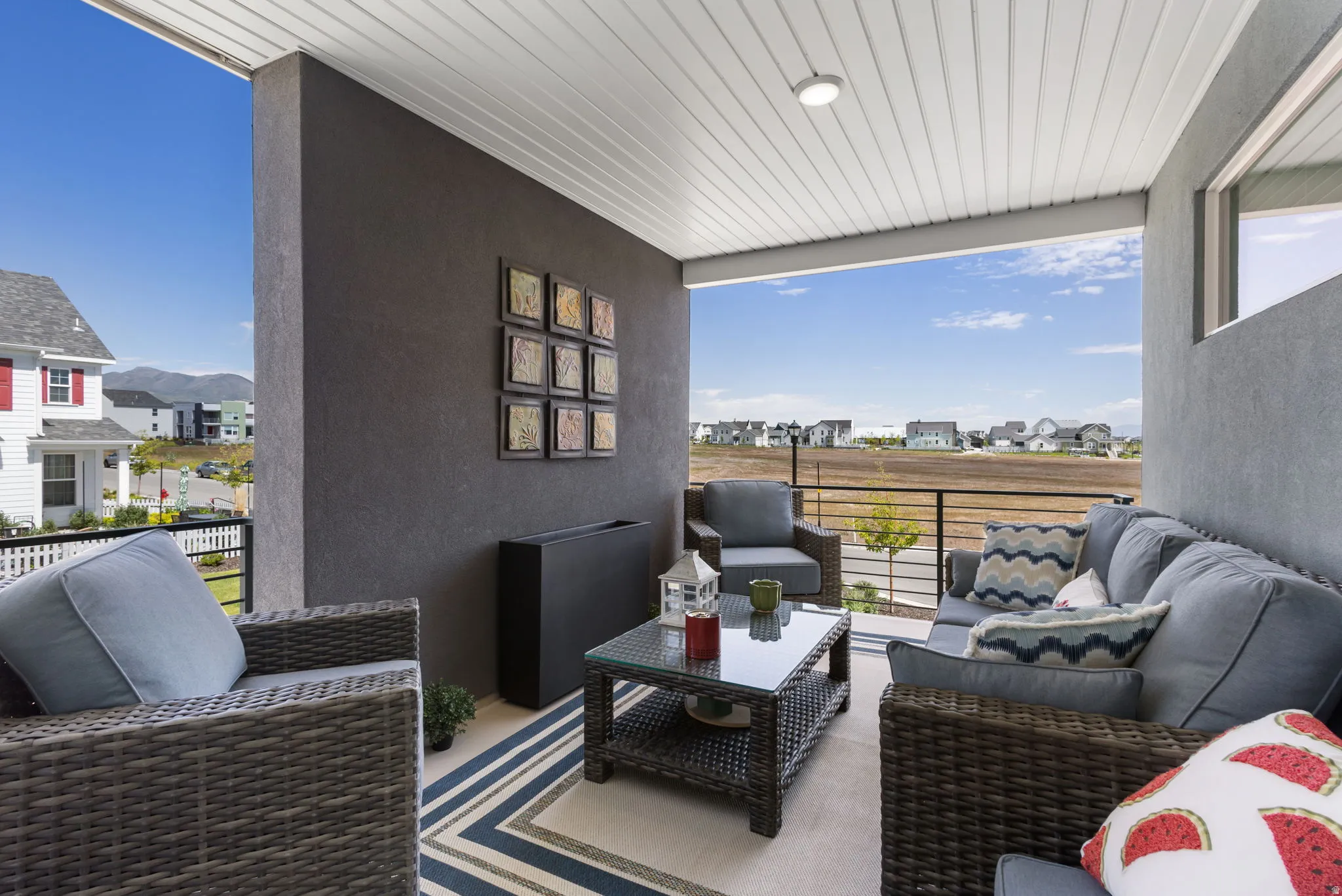 Covered balcony featuring a slat ceiling with recessed lighting, stucco exterior walls, and an iron railing