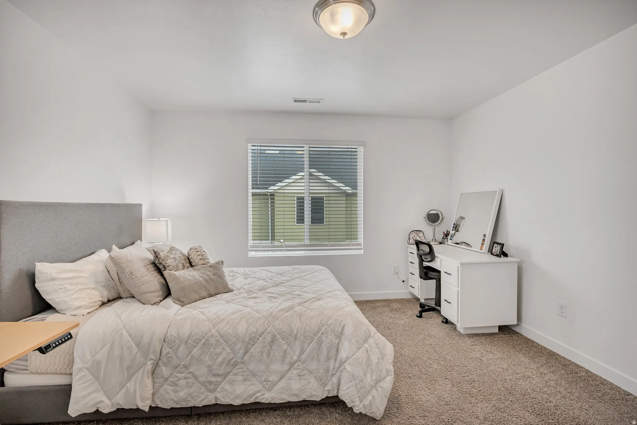Wall-to-wall carpeting and a window featuring horizontal blinds
