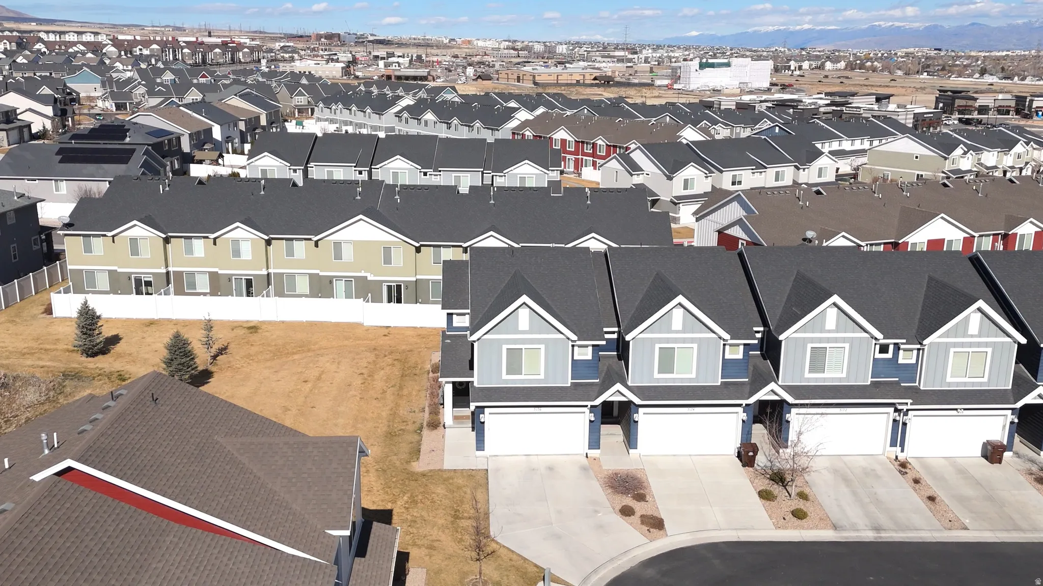 Row of townhomes featuring two-car garages and dark shingle roofing