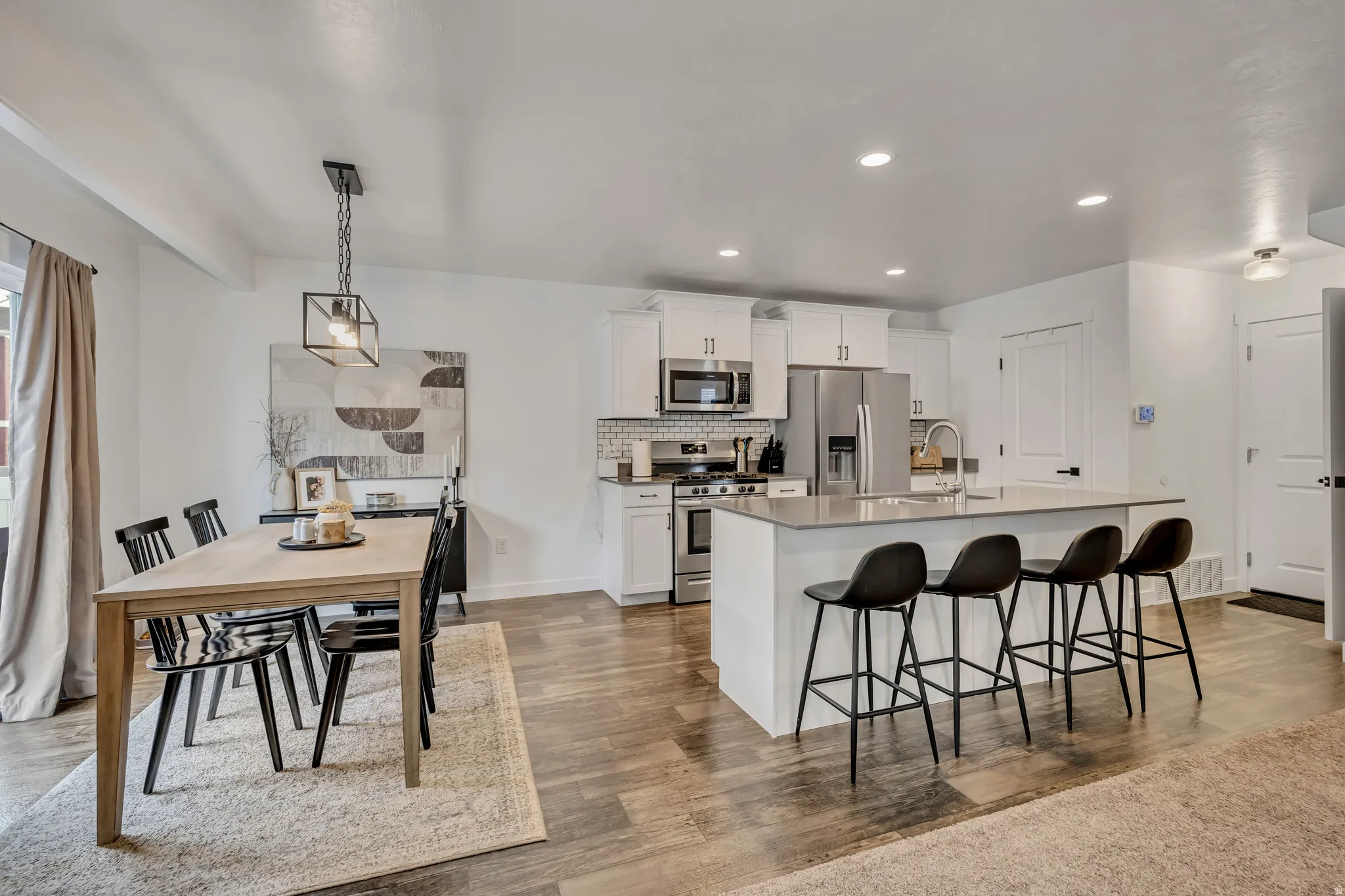 Open-concept kitchen and dining area featuring wood-finish flooring
