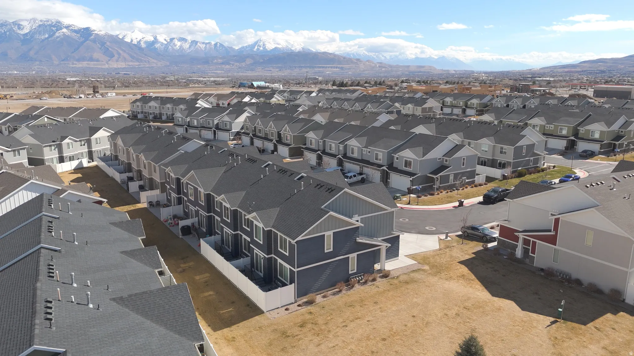Modern residential development featuring multi-story townhomes with dark gray siding and light gray roofs