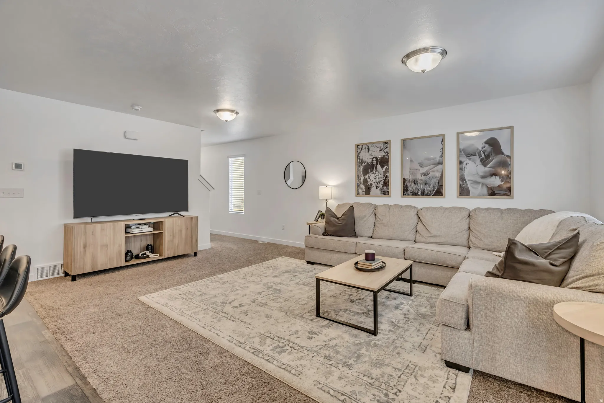 Spacious living room featuring recessed lighting, a neutral color palette, and wall-to-wall carpeting