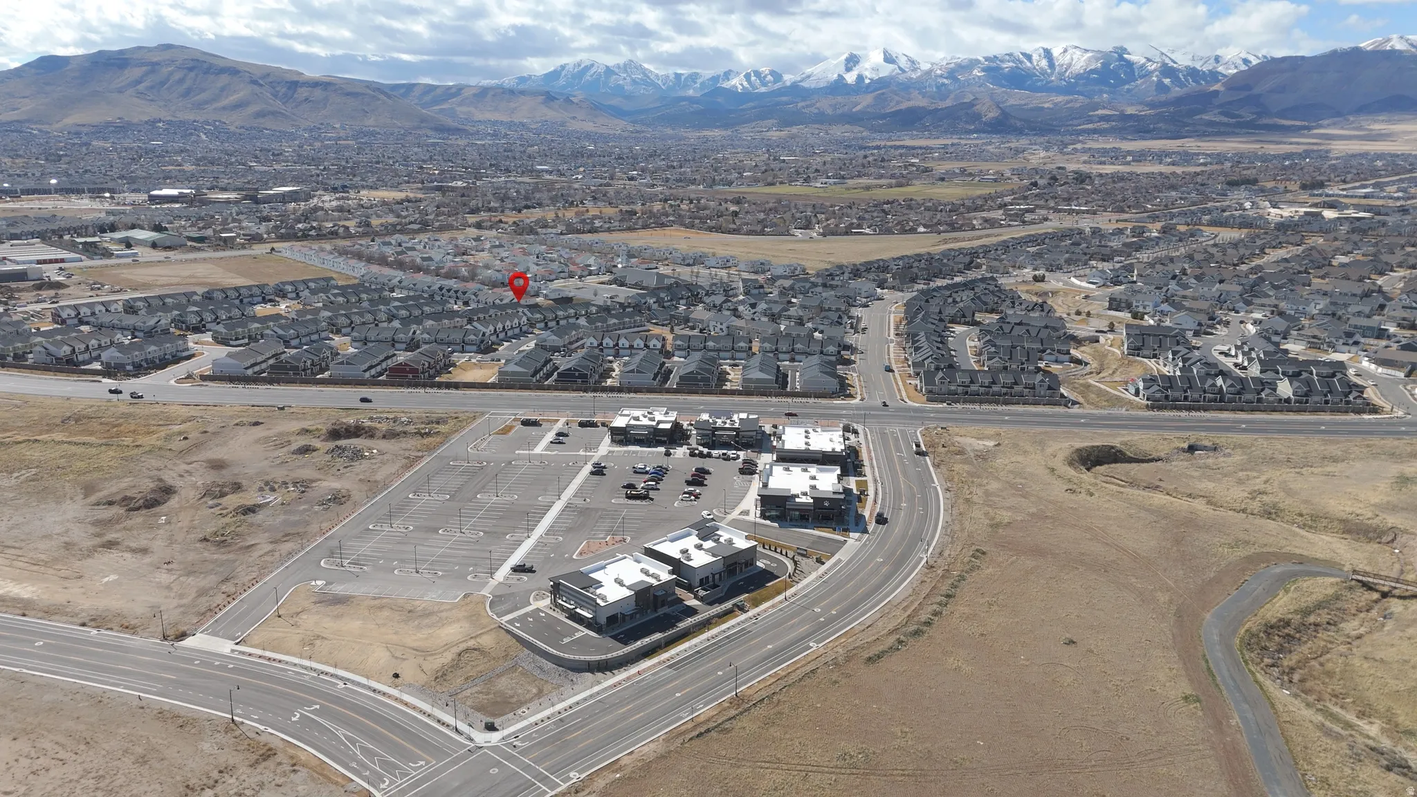 Expansive aerial perspective showcasing a residential community with distant mountain ranges