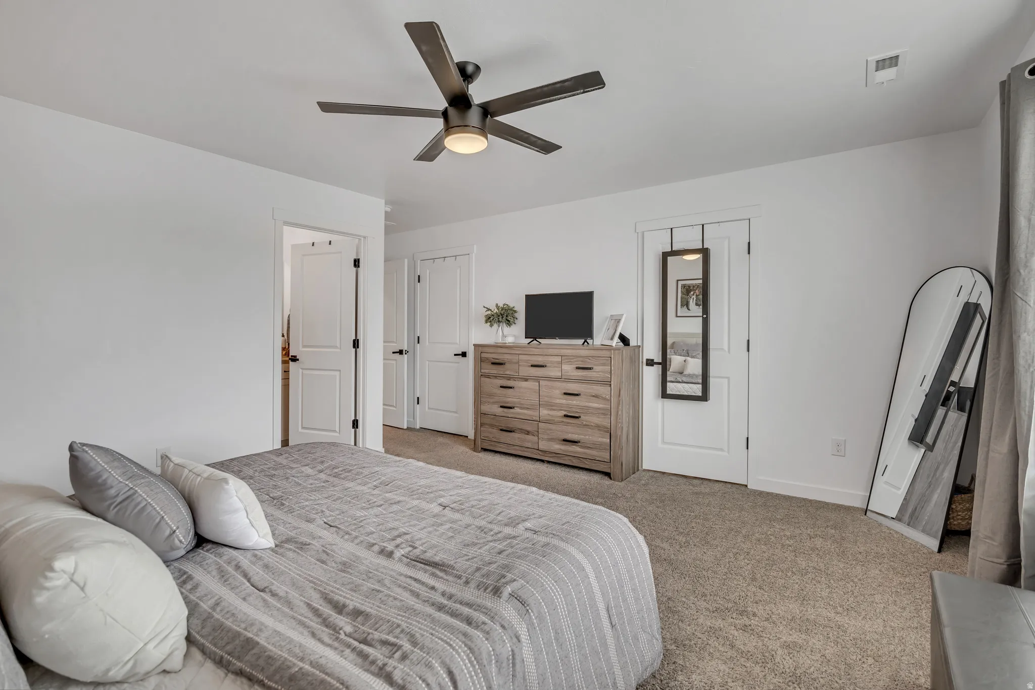 Spacious room featuring neutral carpet flooring and white walls