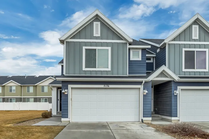 Contemporary exterior featuring blue and gray siding, white trim, and an attached two-car garage