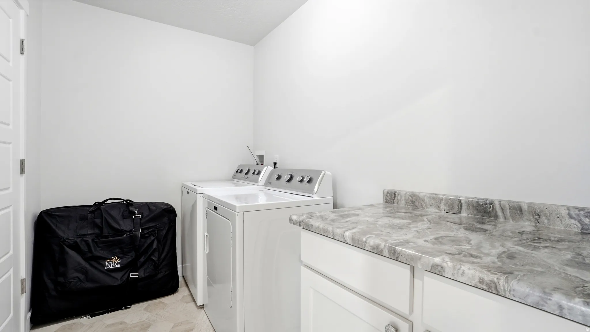 Dedicated laundry area featuring a white top-load washer and front-load dryer