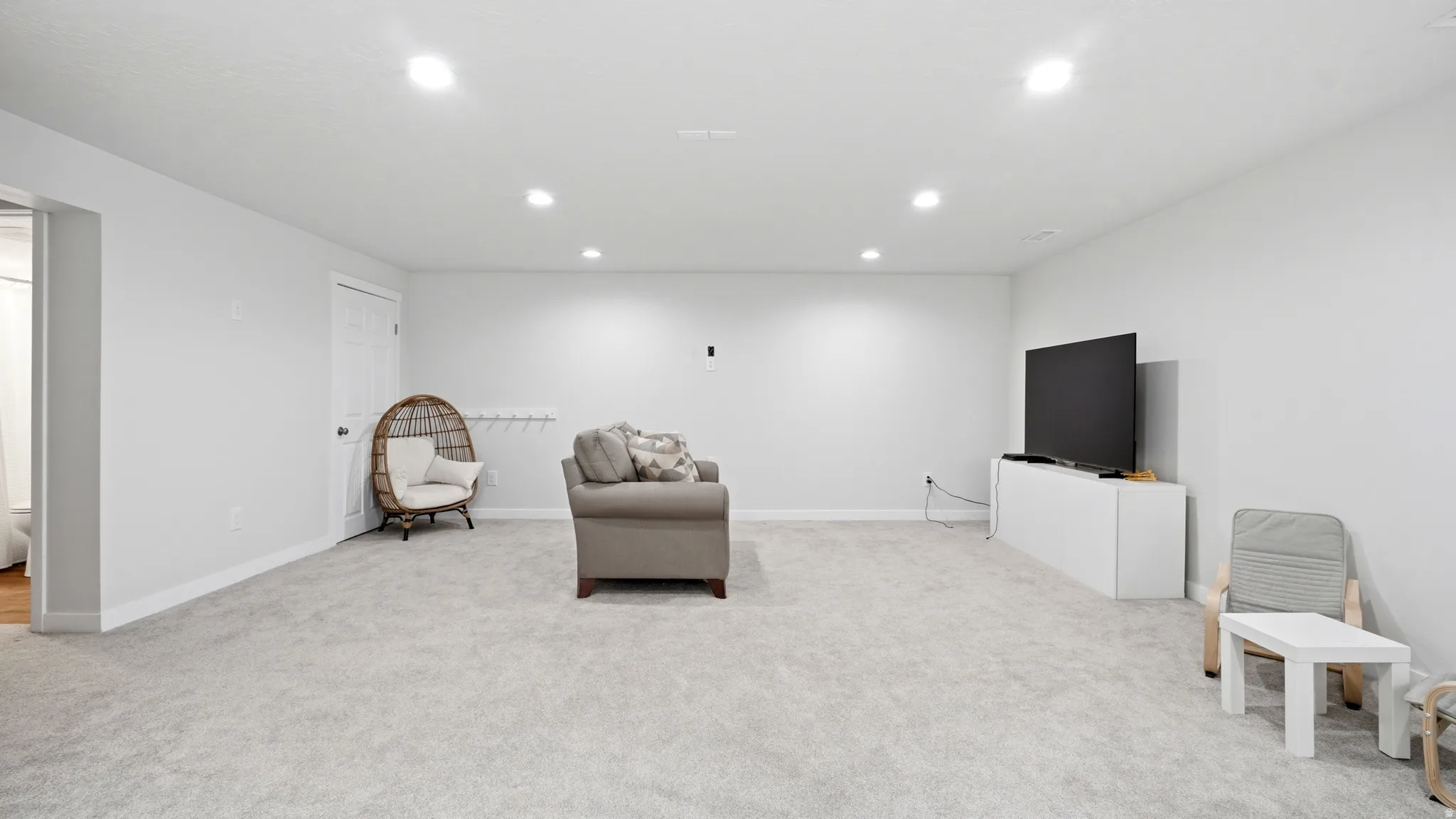 Spacious room featuring light-toned carpeting and recessed lighting