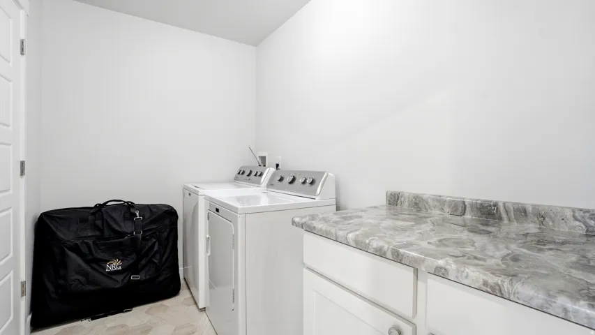 Dedicated laundry area featuring a white top-load washer and front-load dryer