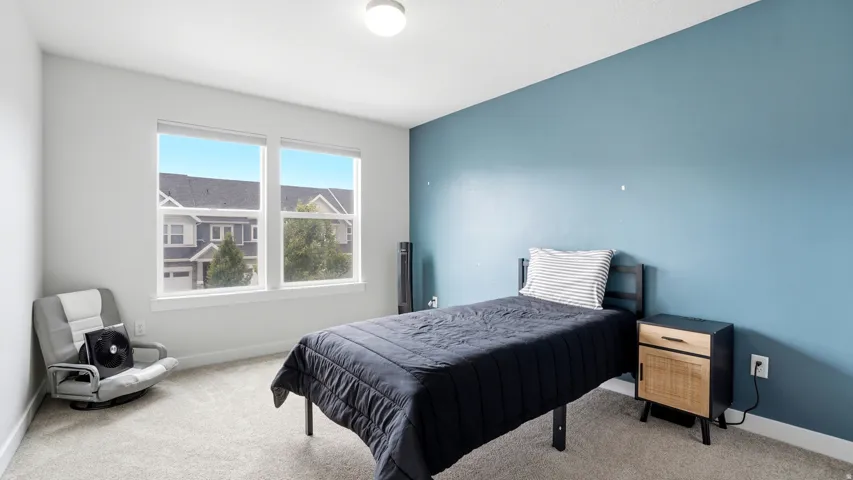 Carpeted room with a blue accent wall and two large windows