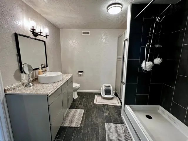 Modern bathroom featuring a spacious vanity with an integrated vessel sink and a wall-mounted tri-light fixture