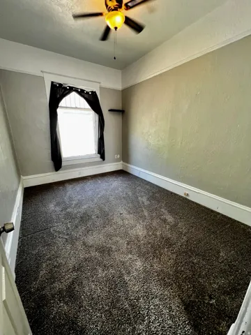 Room featuring wall-to-wall carpeting, light-toned walls, and a ceiling fan with integrated lighting