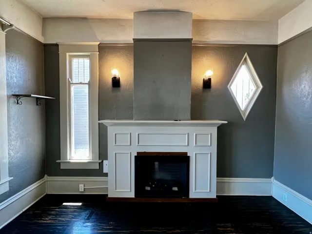 Living area featuring a prominent white fireplace surround with a dark brown hearth