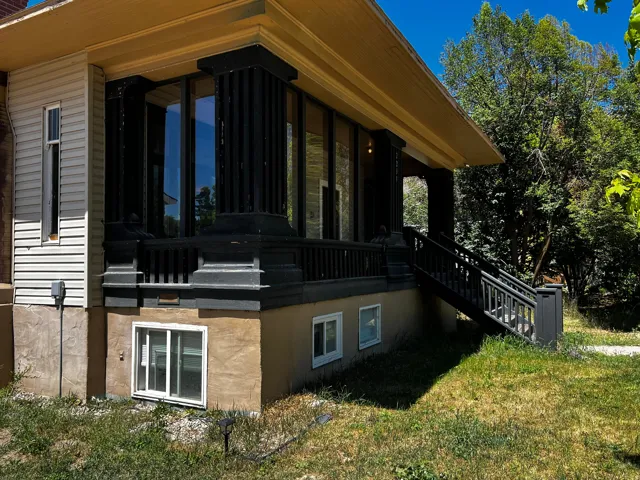 Exterior featuring a covered porch, dark fluted columns, and a railing system
